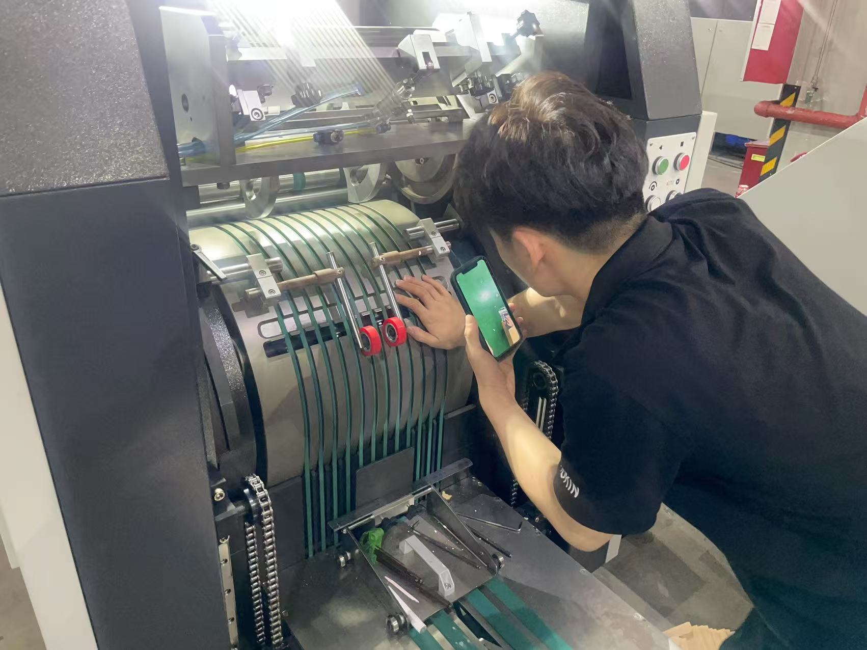 Technician inspecting or adjusting the delivery section of a Paper Bag Machine